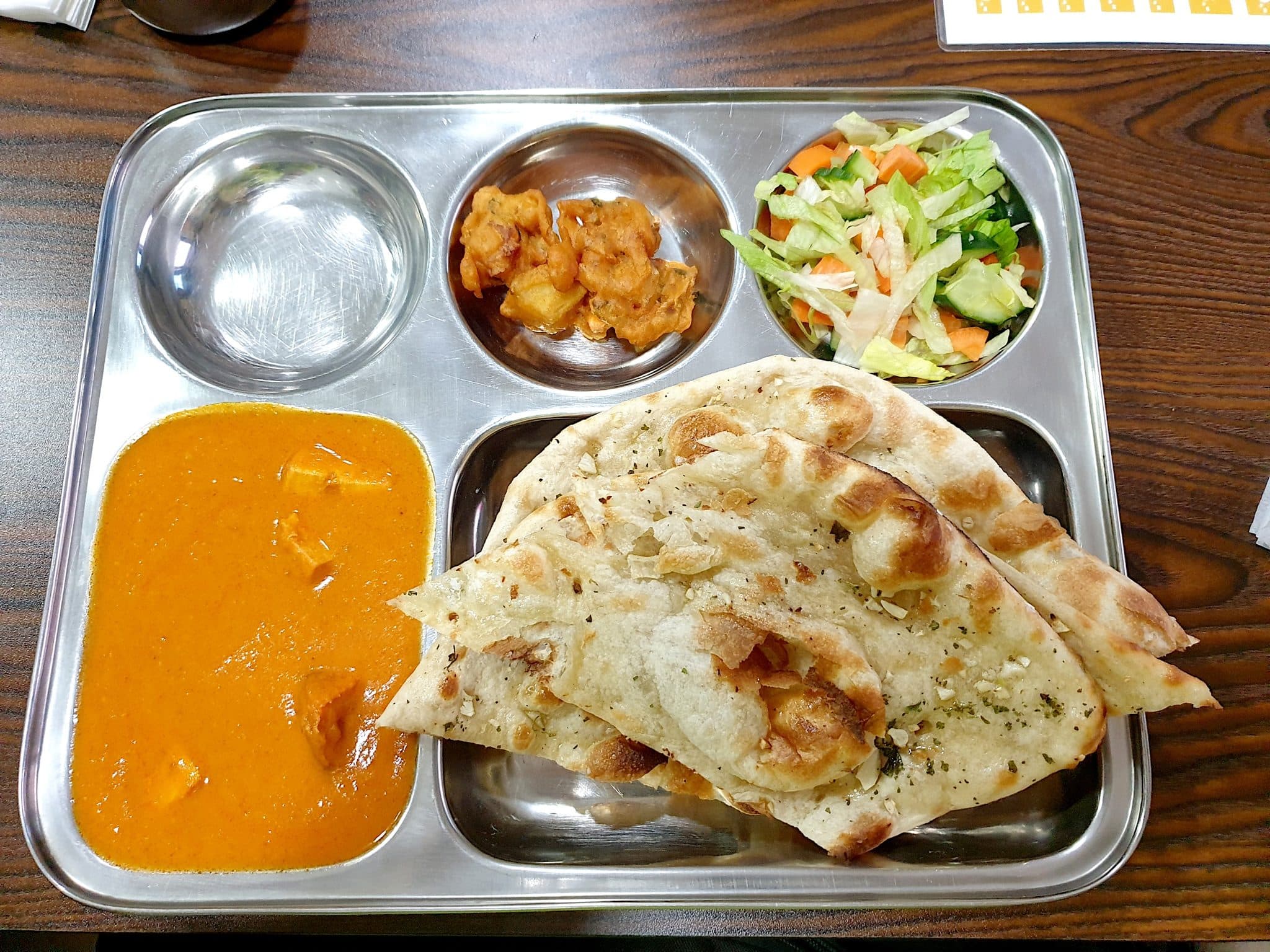 Butter chicken with naan on a tray