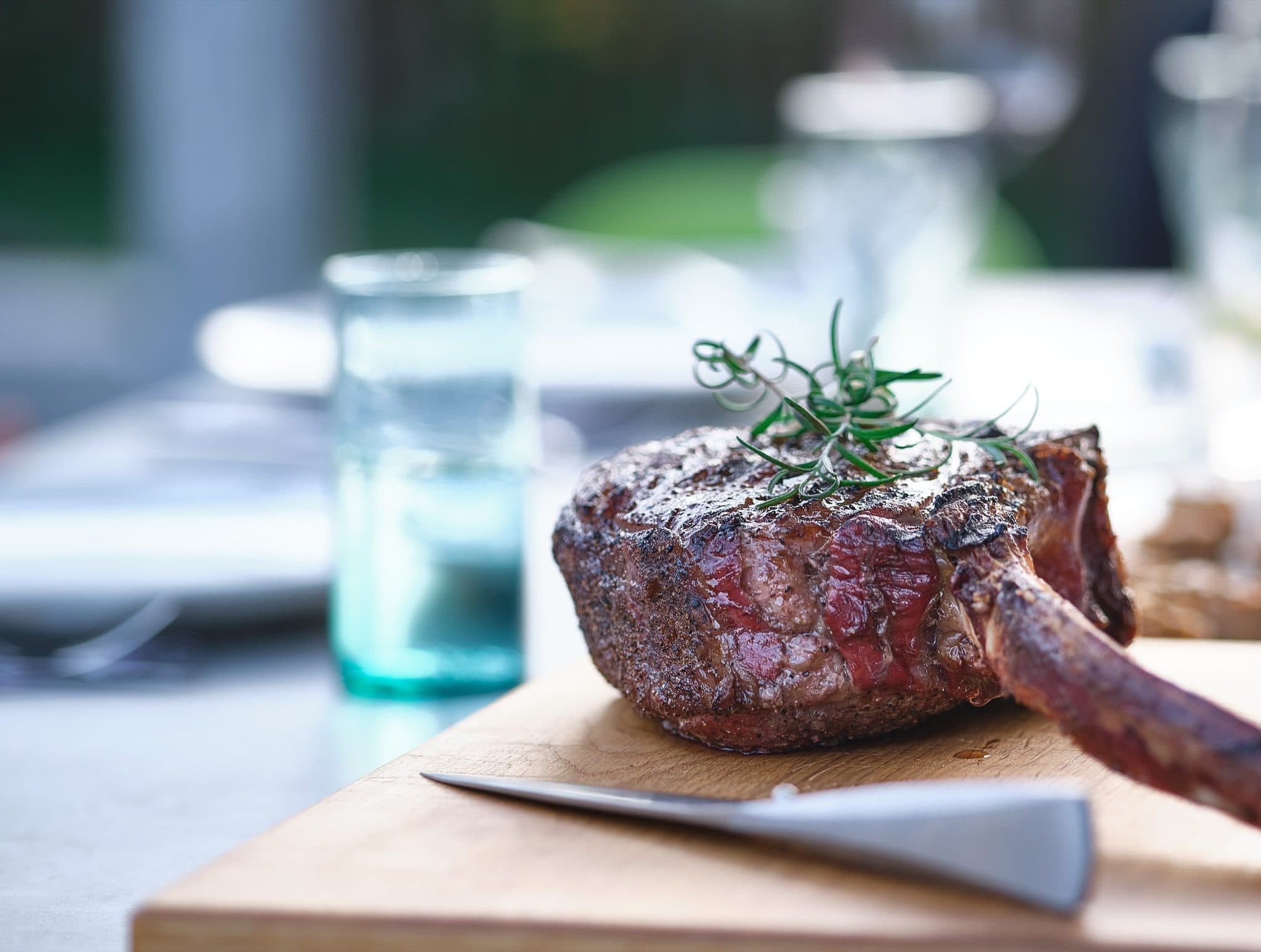 Tomahawk steak with rosemary on a board
